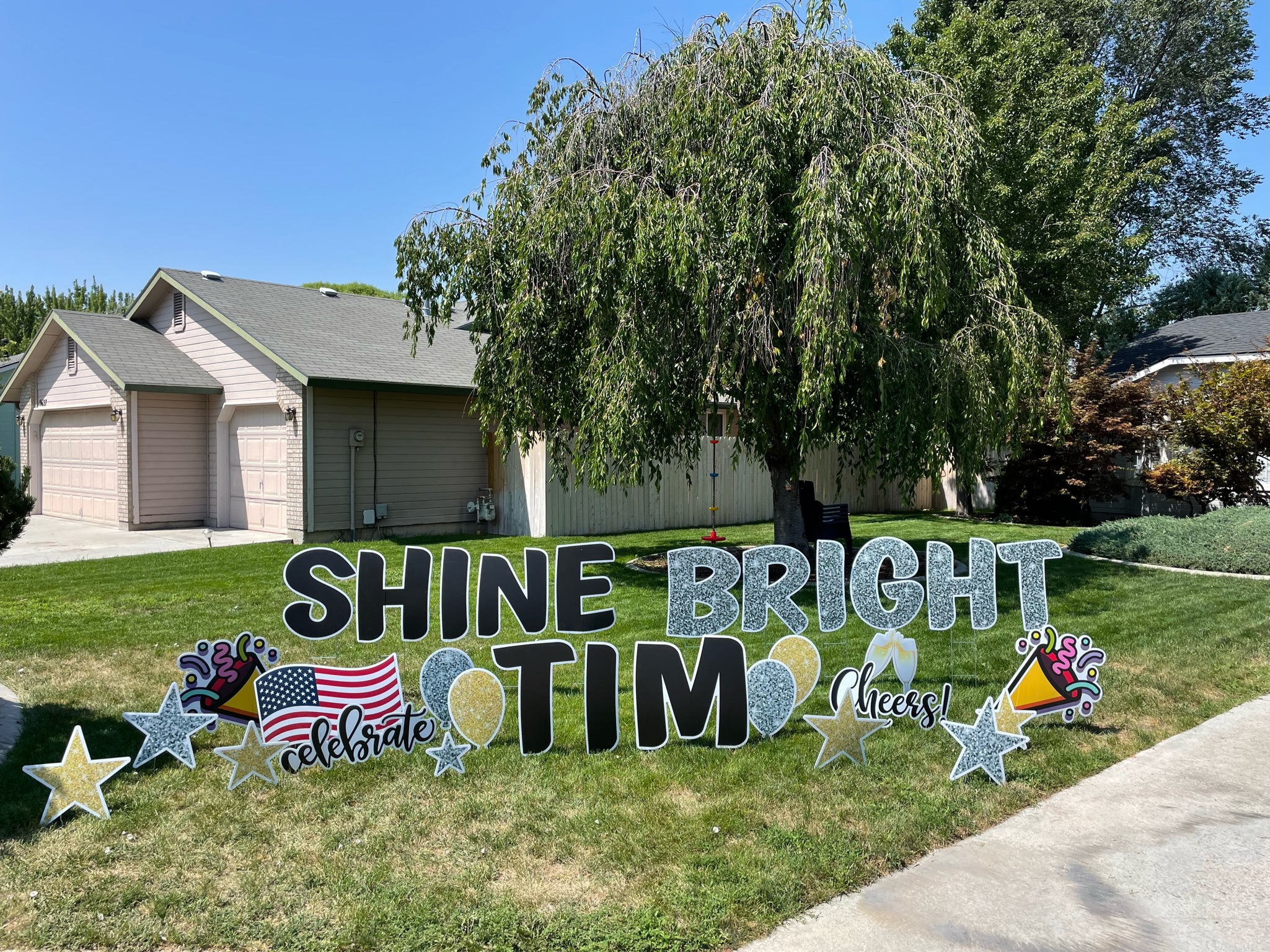 Shine Bright celebration yard card display with black glitter letters and star art in Boise Idaho