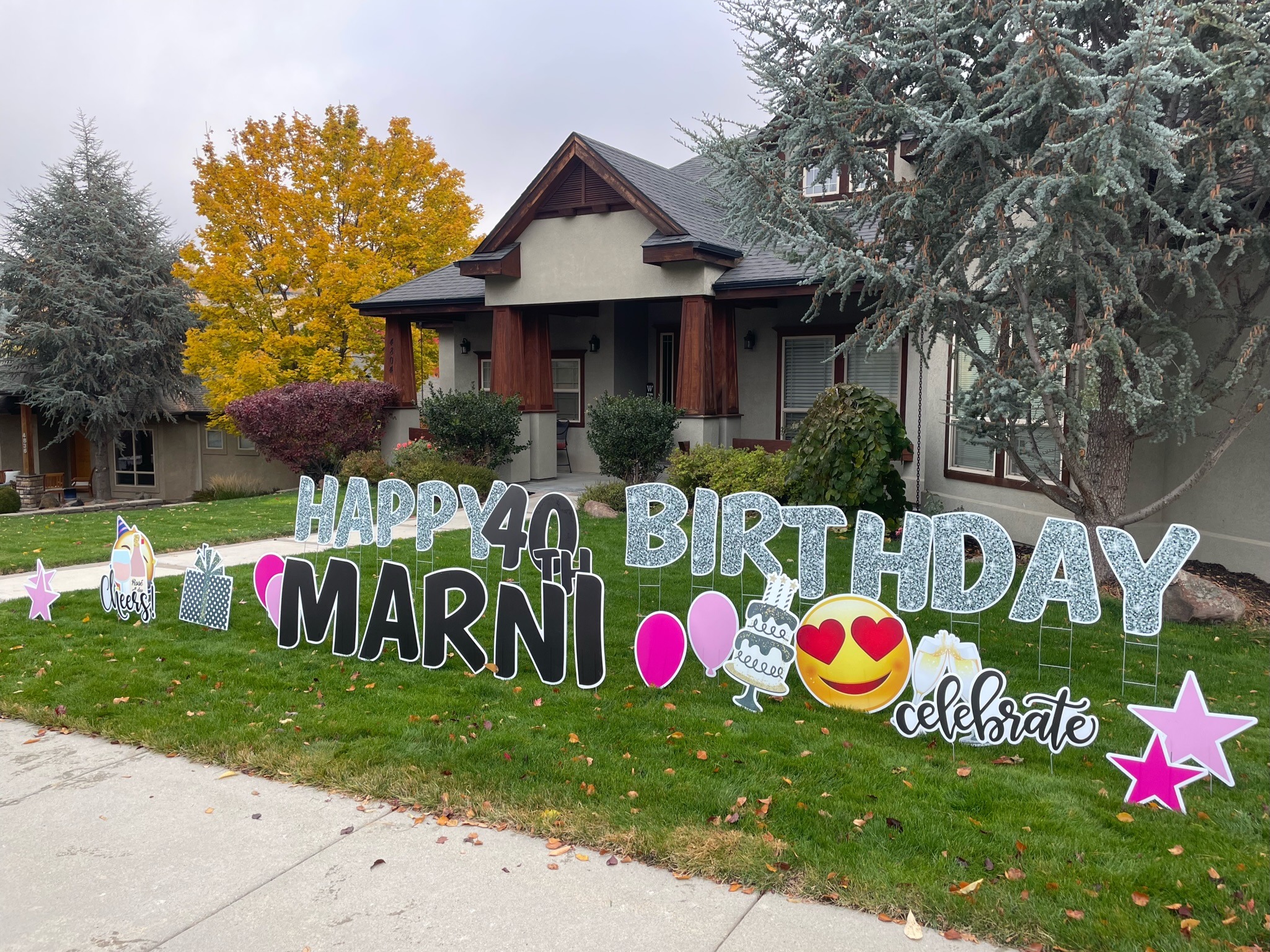 Happy 40th Birthday Marni yard card display with pink glitter letters and celebration art in fall foliage in Boise Idaho